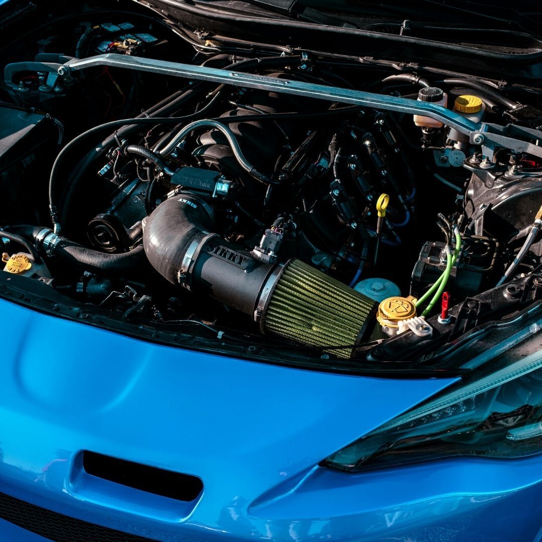 open hood of blue car showing car engine